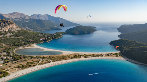 Aerial view of Ölüdeniz Blue Lagoon with turquoise water, beach, and paragliders above.